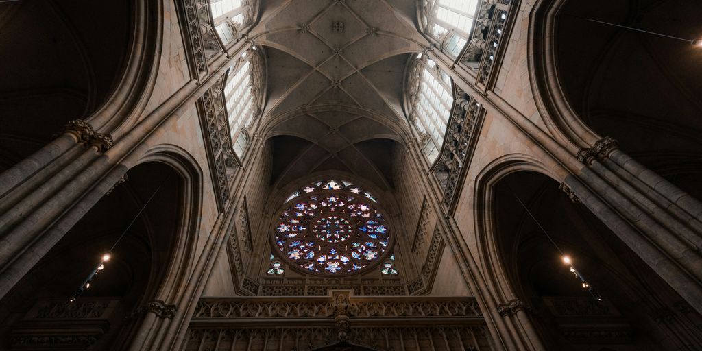the ceiling of a cathedral with a large stained glass window